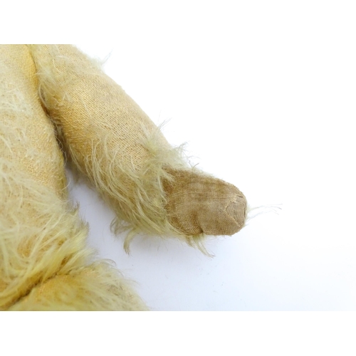 1432 - Toy: A 20thC straw filled mohair teddy bear with stitched nose and mouth, pad paws and articulated l... 