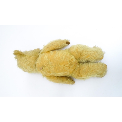 1432 - Toy: A 20thC straw filled mohair teddy bear with stitched nose and mouth, pad paws and articulated l... 