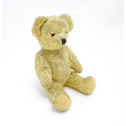 1435 - Toy: A 20thC straw filled teddy bear with stitched nose, mouth, and claws, pad paws and articulated ... 