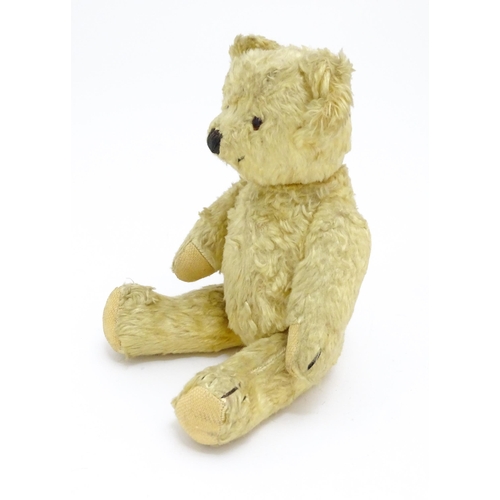 1435 - Toy: A 20thC straw filled teddy bear with stitched nose, mouth, and claws, pad paws and articulated ... 