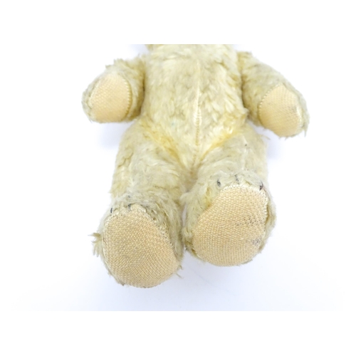 1435 - Toy: A 20thC straw filled teddy bear with stitched nose, mouth, and claws, pad paws and articulated ... 