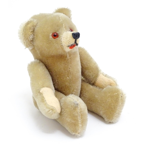 1436 - Toy: A small 20thC plush teddy bear with stitched mouth, fabric tongue, pad paws and articulated lim... 