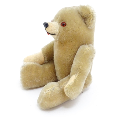 1436 - Toy: A small 20thC plush teddy bear with stitched mouth, fabric tongue, pad paws and articulated lim... 