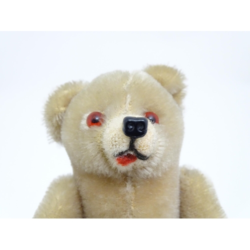 1436 - Toy: A small 20thC plush teddy bear with stitched mouth, fabric tongue, pad paws and articulated lim... 