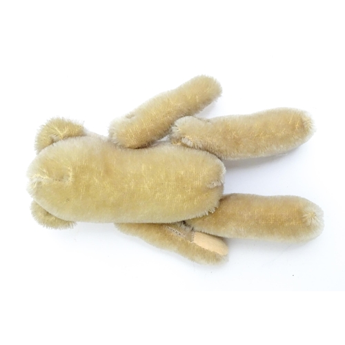 1436 - Toy: A small 20thC plush teddy bear with stitched mouth, fabric tongue, pad paws and articulated lim... 