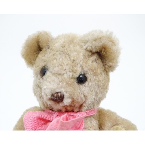 1439 - Toy: A small 20thC teddy bear with stitched nose, mouth and claws, pad paws, articulated limbs and a... 