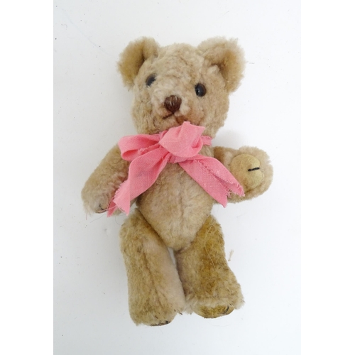 1439 - Toy: A small 20thC teddy bear with stitched nose, mouth and claws, pad paws, articulated limbs and a... 