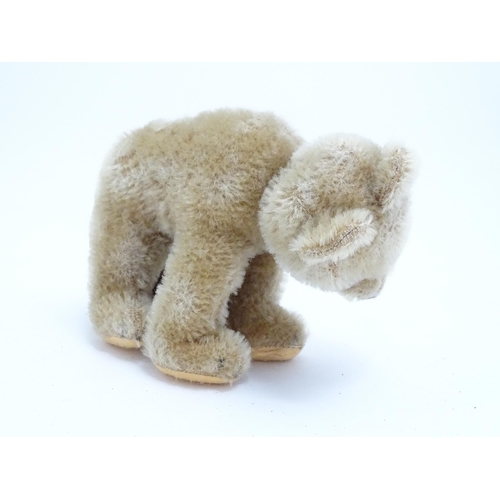 1443 - Toys: A 20thC straw filled mohair teddy bear on all four legs with a stitched nose, mouth and claws,... 