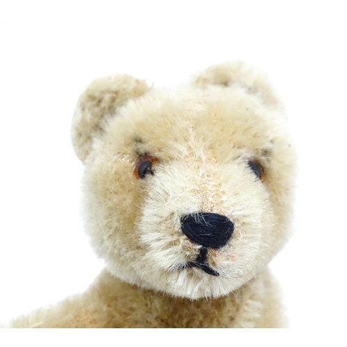 1443 - Toys: A 20thC straw filled mohair teddy bear on all four legs with a stitched nose, mouth and claws,... 