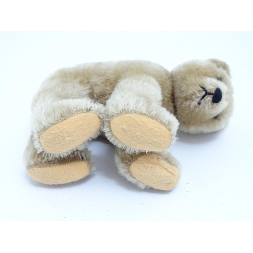 1443 - Toys: A 20thC straw filled mohair teddy bear on all four legs with a stitched nose, mouth and claws,... 