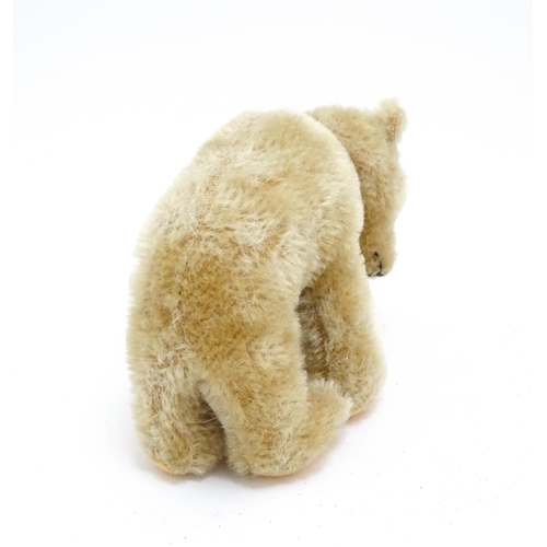 1443 - Toys: A 20thC straw filled mohair teddy bear on all four legs with a stitched nose, mouth and claws,... 