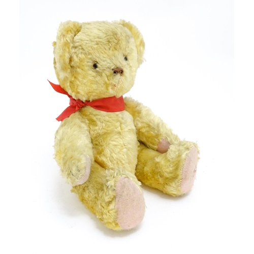 1446 - Toy: A 20thC plush teddy bear with scrolled nose, pad paws and articulated limbs. Approx. 11