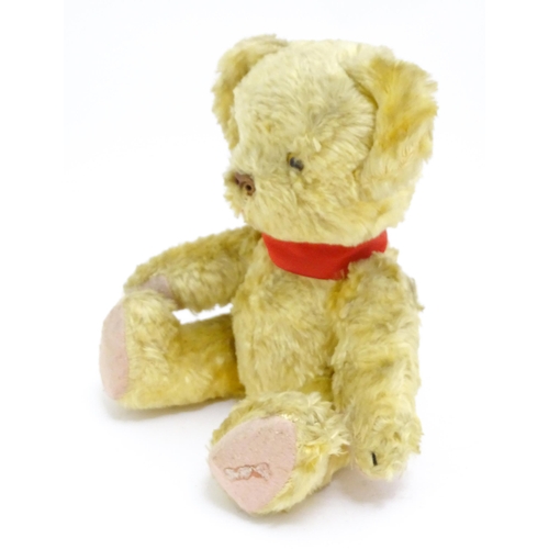 1446 - Toy: A 20thC plush teddy bear with scrolled nose, pad paws and articulated limbs. Approx. 11