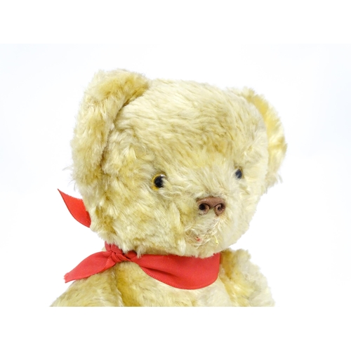 1446 - Toy: A 20thC plush teddy bear with scrolled nose, pad paws and articulated limbs. Approx. 11