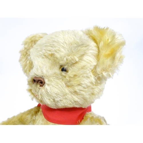 1446 - Toy: A 20thC plush teddy bear with scrolled nose, pad paws and articulated limbs. Approx. 11