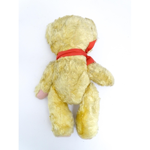 1446 - Toy: A 20thC plush teddy bear with scrolled nose, pad paws and articulated limbs. Approx. 11