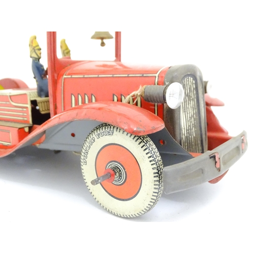 1455 - Toys: An early 20thC Mettoy tin plate clockwork fire engine with two firemen figures, a yellow ladde... 