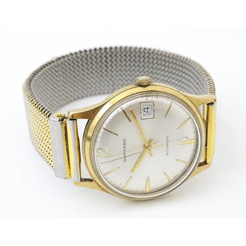 818 - A 9ct gold cased Garrard Automatic wristwatch, the dial with date aperture at 3 . Approx 1 /4