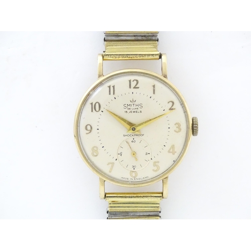 821 - A 9ct gold cased Smiths wristwatch, the dial signed ' Smiths De Luxe 15 jewels Shockproof , with sec... 