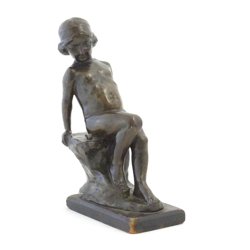 1099 - An early 20thC cast figure depicting a young boy on a rock plinth. Indistinctly signed to base Flore... 