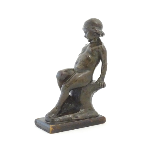 1099 - An early 20thC cast figure depicting a young boy on a rock plinth. Indistinctly signed to base Flore... 