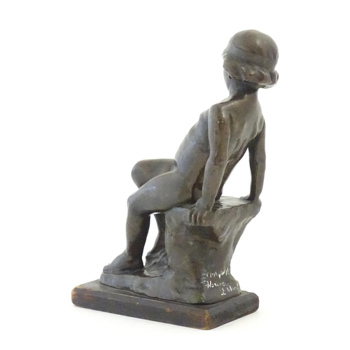 1099 - An early 20thC cast figure depicting a young boy on a rock plinth. Indistinctly signed to base Flore... 