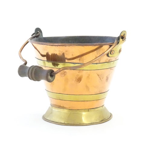 1104 - A small early 20thC copper and brass bucket of tapering form with swing handle. Approx. 7 1/2