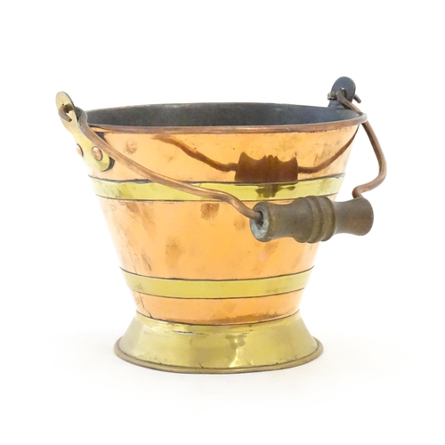 1104 - A small early 20thC copper and brass bucket of tapering form with swing handle. Approx. 7 1/2