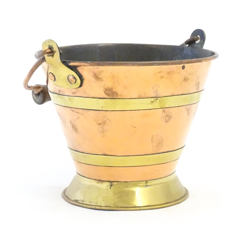 1104 - A small early 20thC copper and brass bucket of tapering form with swing handle. Approx. 7 1/2