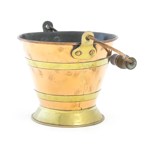 1104 - A small early 20thC copper and brass bucket of tapering form with swing handle. Approx. 7 1/2