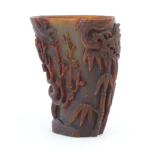 1118 - An Oriental carved horn libation cup decorated with birds, bamboo, flowering trees, etc. Approx. 5