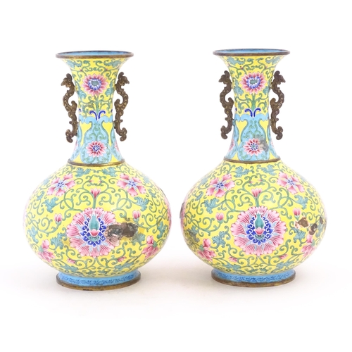 1124 - A pair of Oriental cloisonne vases with twin handles, yellow ground decorated with flowers and scrol... 