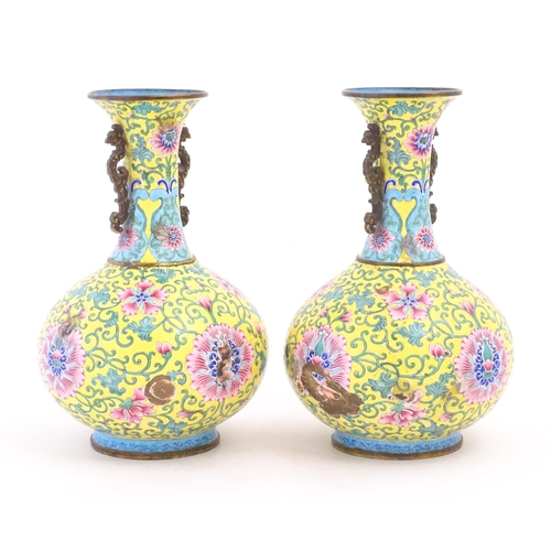 1124 - A pair of Oriental cloisonne vases with twin handles, yellow ground decorated with flowers and scrol... 