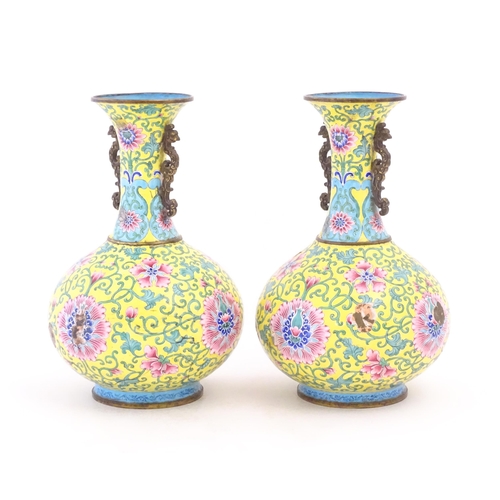 1124 - A pair of Oriental cloisonne vases with twin handles, yellow ground decorated with flowers and scrol... 