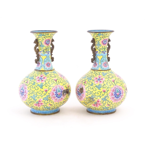 1124 - A pair of Oriental cloisonne vases with twin handles, yellow ground decorated with flowers and scrol... 