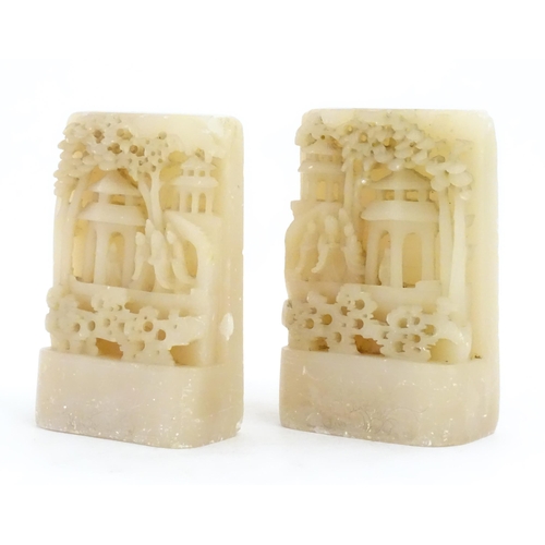 1126 - A pair of Oriental carved soapstone bookends depicting figures, pagoda style buildings and trees. Ap... 