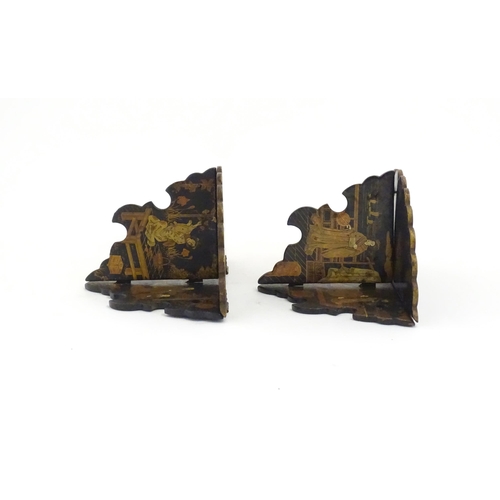 1134 - A pair of Oriental lacquered papier mache folding wall brackets decorated with figures in gardens an... 