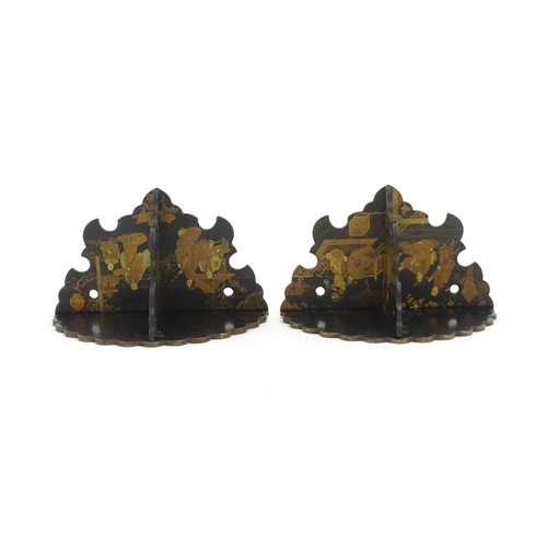 1134 - A pair of Oriental lacquered papier mache folding wall brackets decorated with figures in gardens an... 