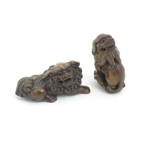 1137 - Two Japanese carved hardwood netsukes modelled as guardian lions / foo dogs. Both signed under. Larg... 