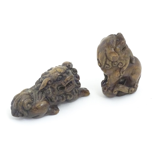 1137 - Two Japanese carved hardwood netsukes modelled as guardian lions / foo dogs. Both signed under. Larg... 