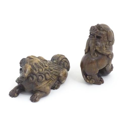 1137 - Two Japanese carved hardwood netsukes modelled as guardian lions / foo dogs. Both signed under. Larg... 