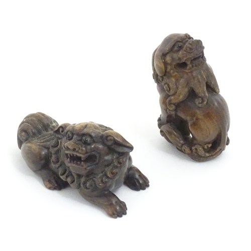 1137 - Two Japanese carved hardwood netsukes modelled as guardian lions / foo dogs. Both signed under. Larg... 