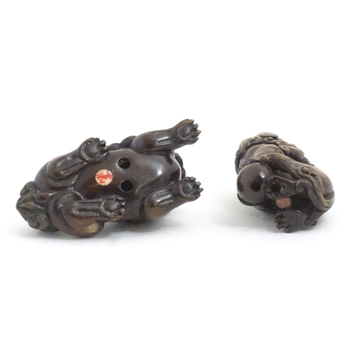 1137 - Two Japanese carved hardwood netsukes modelled as guardian lions / foo dogs. Both signed under. Larg... 