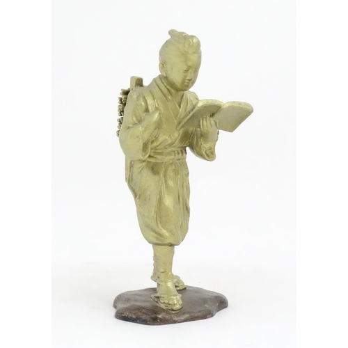 1147 - An Oriental cast sculpture modelled as a scholar reading a book. Approx. 10 1/4