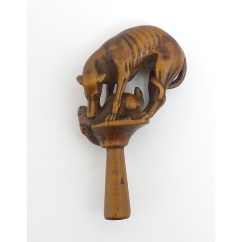 1167 - An early 19thC treen boxwood pipe tamper modelled as a greyhound dog retrieving a hare. Approx. 3 1/... 