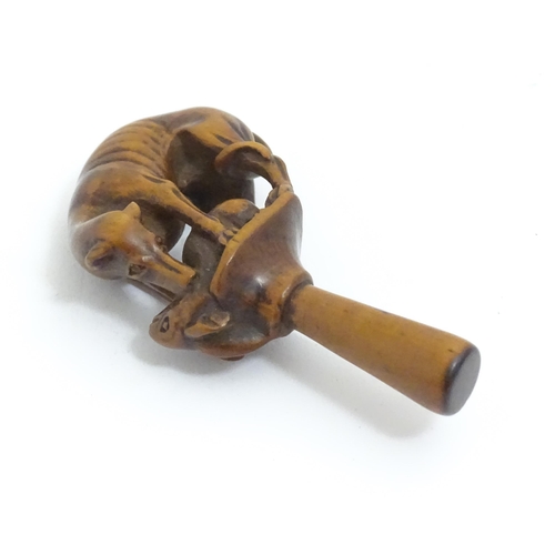 1167 - An early 19thC treen boxwood pipe tamper modelled as a greyhound dog retrieving a hare. Approx. 3 1/... 