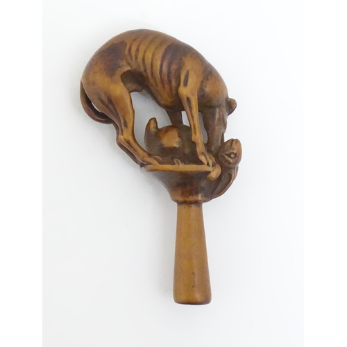 1167 - An early 19thC treen boxwood pipe tamper modelled as a greyhound dog retrieving a hare. Approx. 3 1/... 