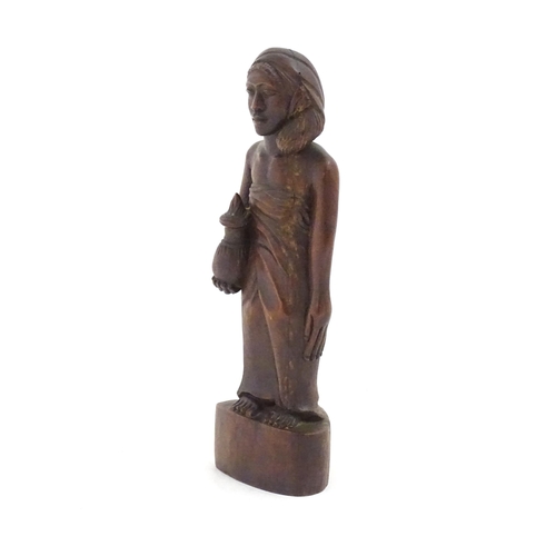 1184 - Ethnographic / Native / Tribal: An African carved wood figure modelled as a lady holding a vessel. A... 