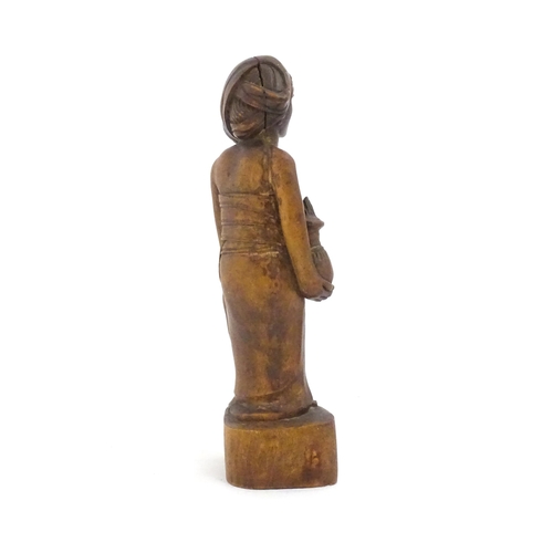 1184 - Ethnographic / Native / Tribal: An African carved wood figure modelled as a lady holding a vessel. A... 