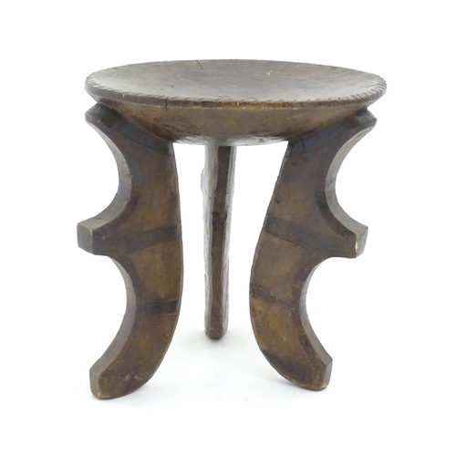 1187 - Ethnographic / Native / Tribal: A three legged African stool with carved detail. Approx. 19 1/2